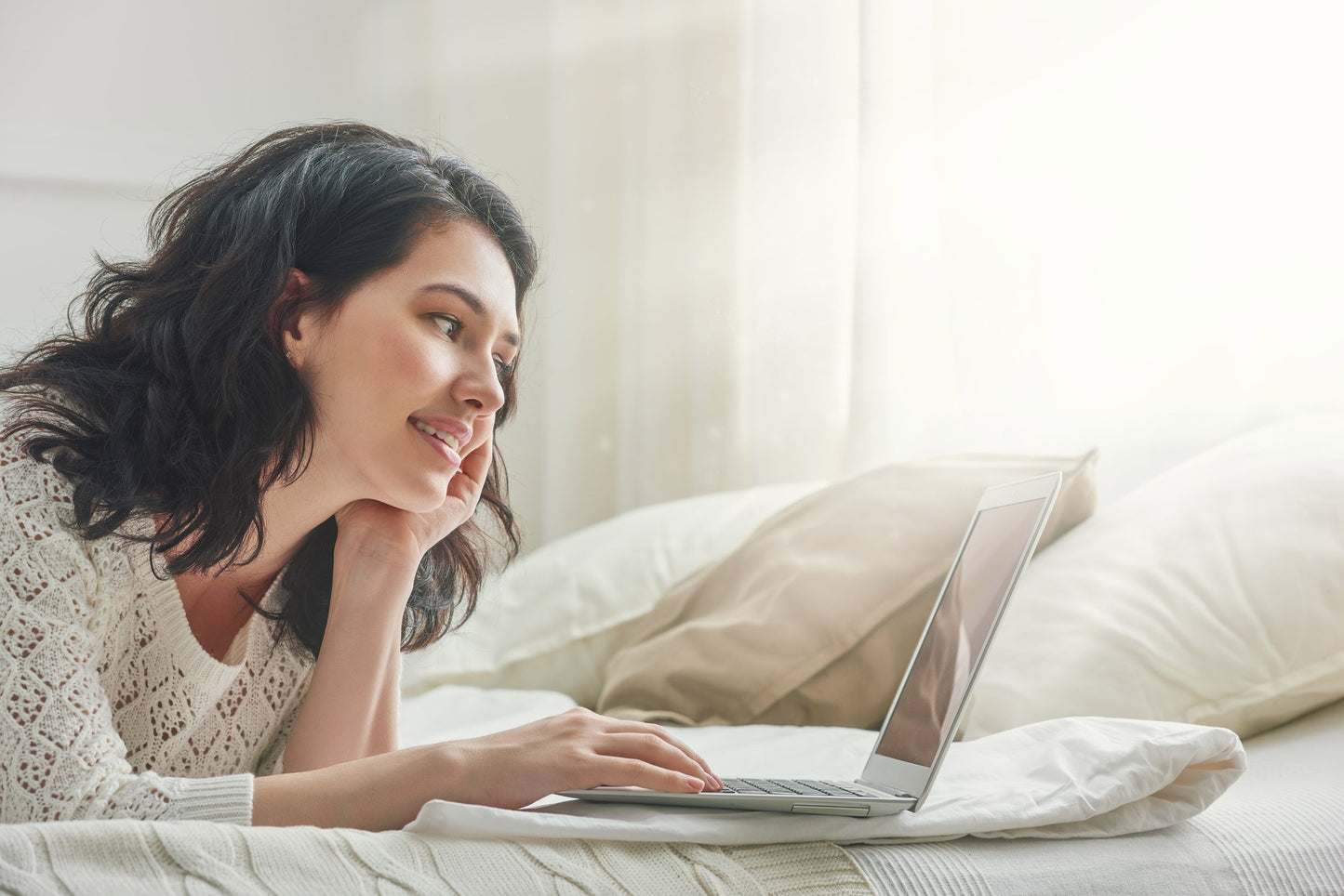 woman-lying-on-spring-air-mattress-working-on-laptop