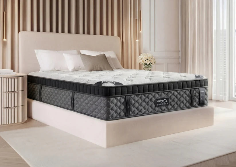 Three-quarter angle view of the thick 16-inch Puffy Monarch mattress highlighting the multi-layer hybrid profile.